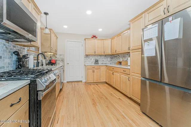 a kitchen with stainless steel appliances granite countertop a stove and a refrigerator