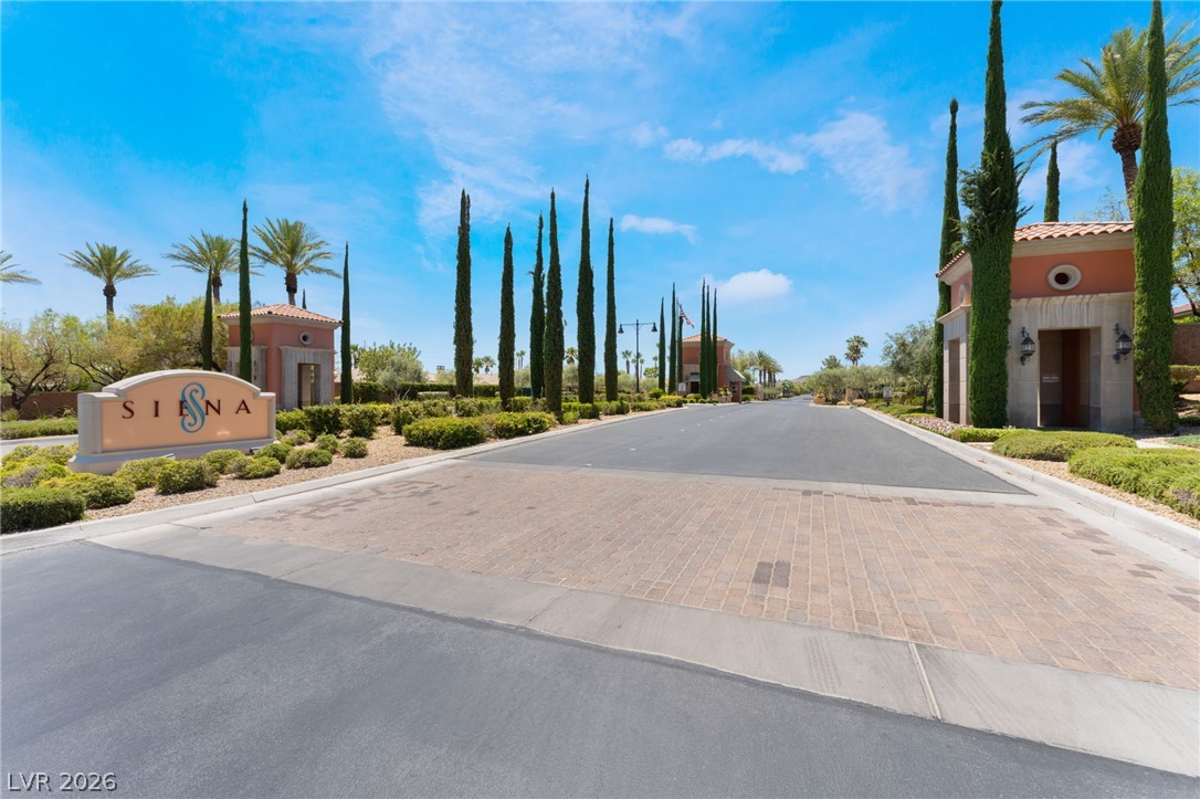 5389 Progresso Street Las Vegas, NV 89135 - Photo 37 of 41 An inviting gated community entrance awaits, flanked by elegant palm trees and lush greenery.