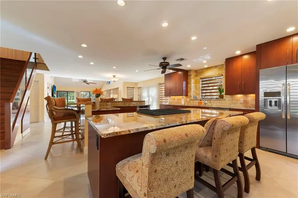 a dining hall with stainless steel appliances granite countertop furniture and a counter top space