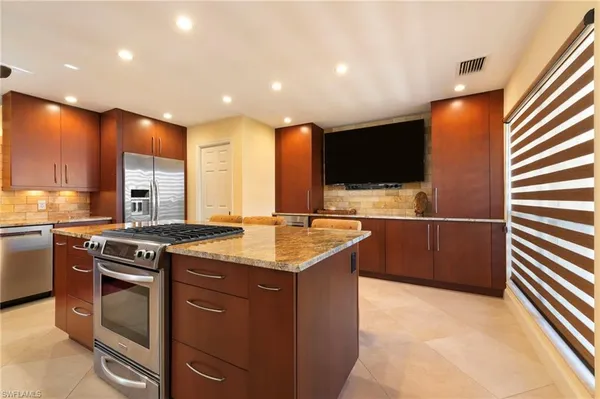 a kitchen with stainless steel appliances granite countertop a sink and a stove