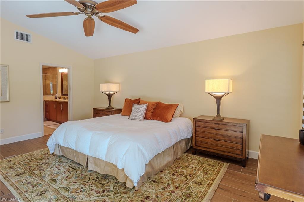 11737 Quail Village Way Naples, FL 34119 - Photo 16 of 50 a bedroom with a bed and a chandelier