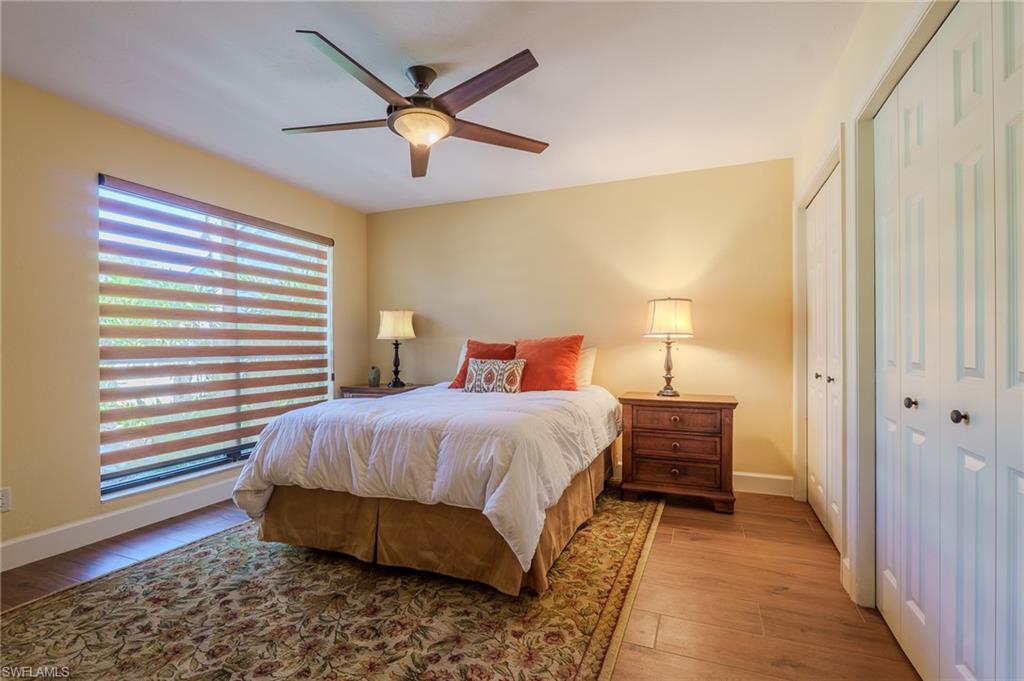 11737 Quail Village Way Naples, FL 34119 - Photo 22 of 50 a bedroom with a bed and wooden floor