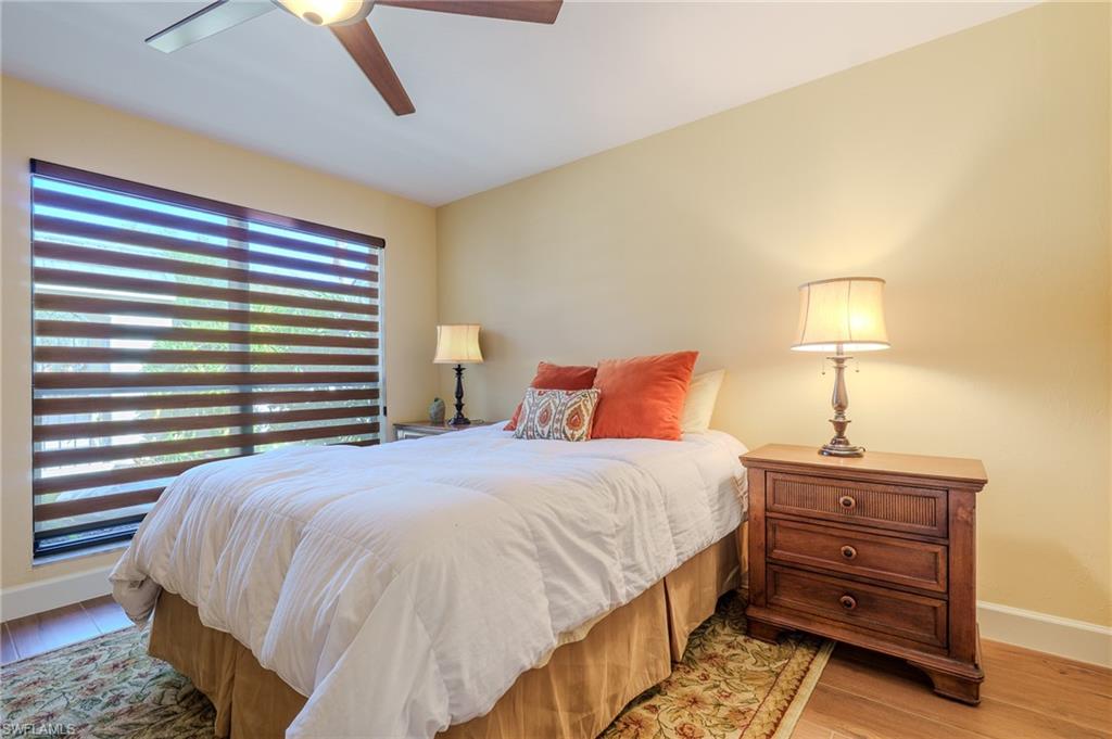 11737 Quail Village Way Naples, FL 34119 - Photo 24 of 50 a bedroom with a bed and a lamp