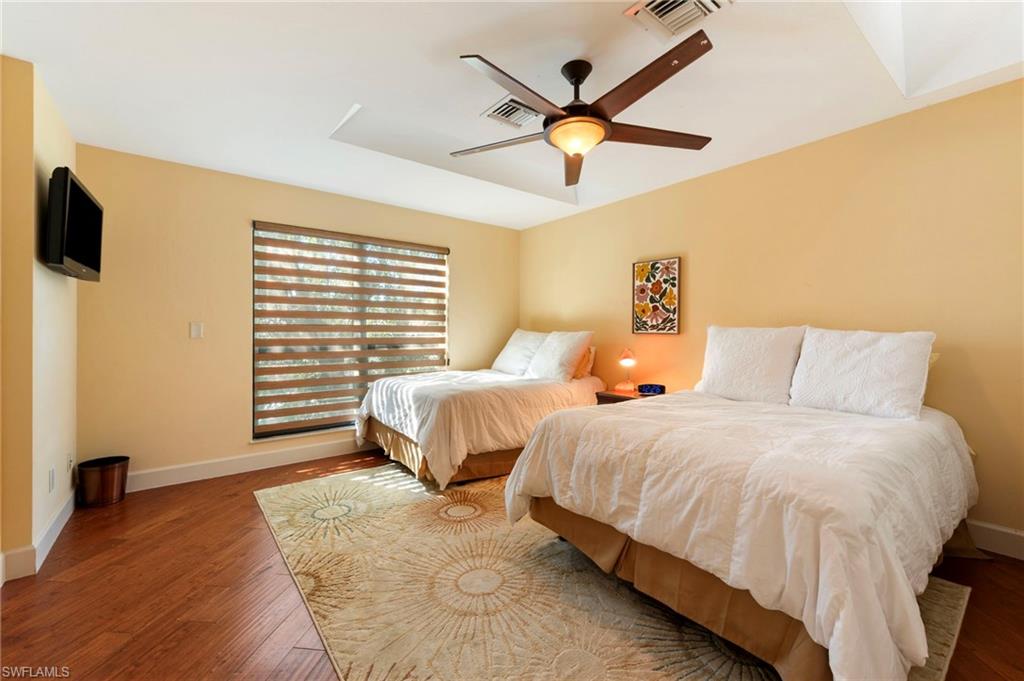 11737 Quail Village Way Naples, FL 34119 - Photo 27 of 50 a bedroom with a bed and a ceiling fan