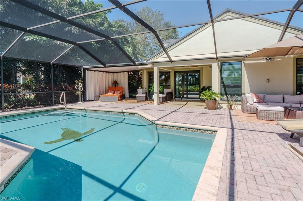 11737 Quail Village Way Naples, FL 34119 - Photo 36 of 50 a view of a patio with a table and chairs under an umbrella