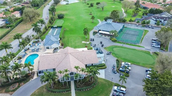 a view of a dining room with furniture a chandelier and kitchen view