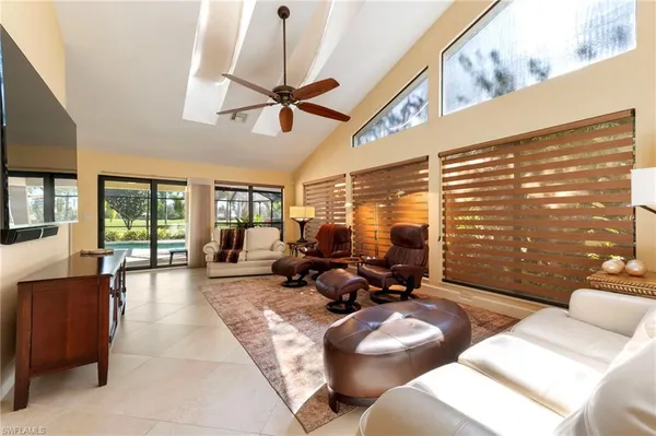 a living room with furniture floor to ceiling window and a flat screen tv