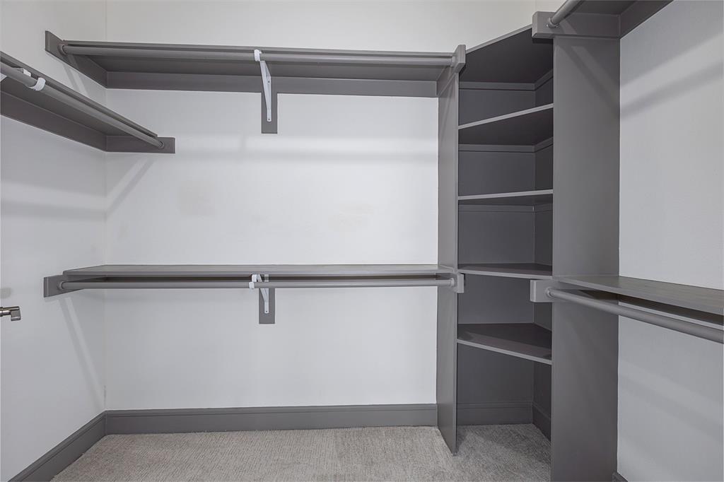 2700 Old Denton Road, Unit 1044 Carrollton, TX 75007 - Photo 14 of 33 Walk-in closet featuring built-in shelving, multiple hanging rods, and corner storage