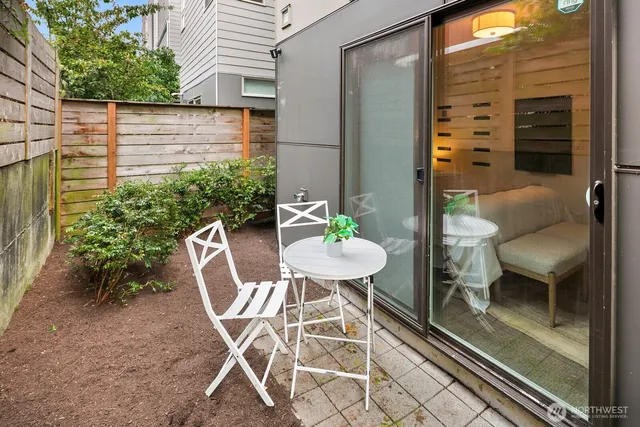 a roof deck with a dining table and chairs with wooden floor