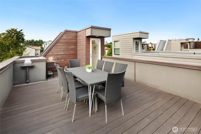 a view of a roof deck with table and chairs
