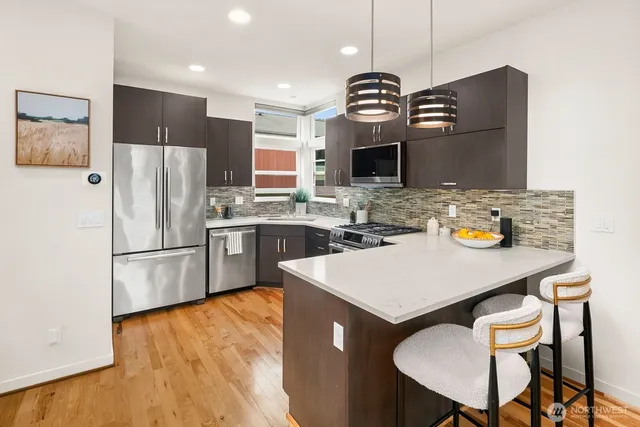 a kitchen with stainless steel appliances granite countertop a refrigerator and a stove top oven