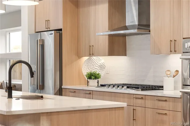 a kitchen with stainless steel appliances granite countertop a sink a stove and a refrigerator