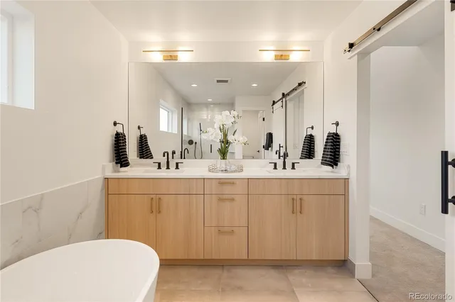 a bathroom with a tub shower and mirror