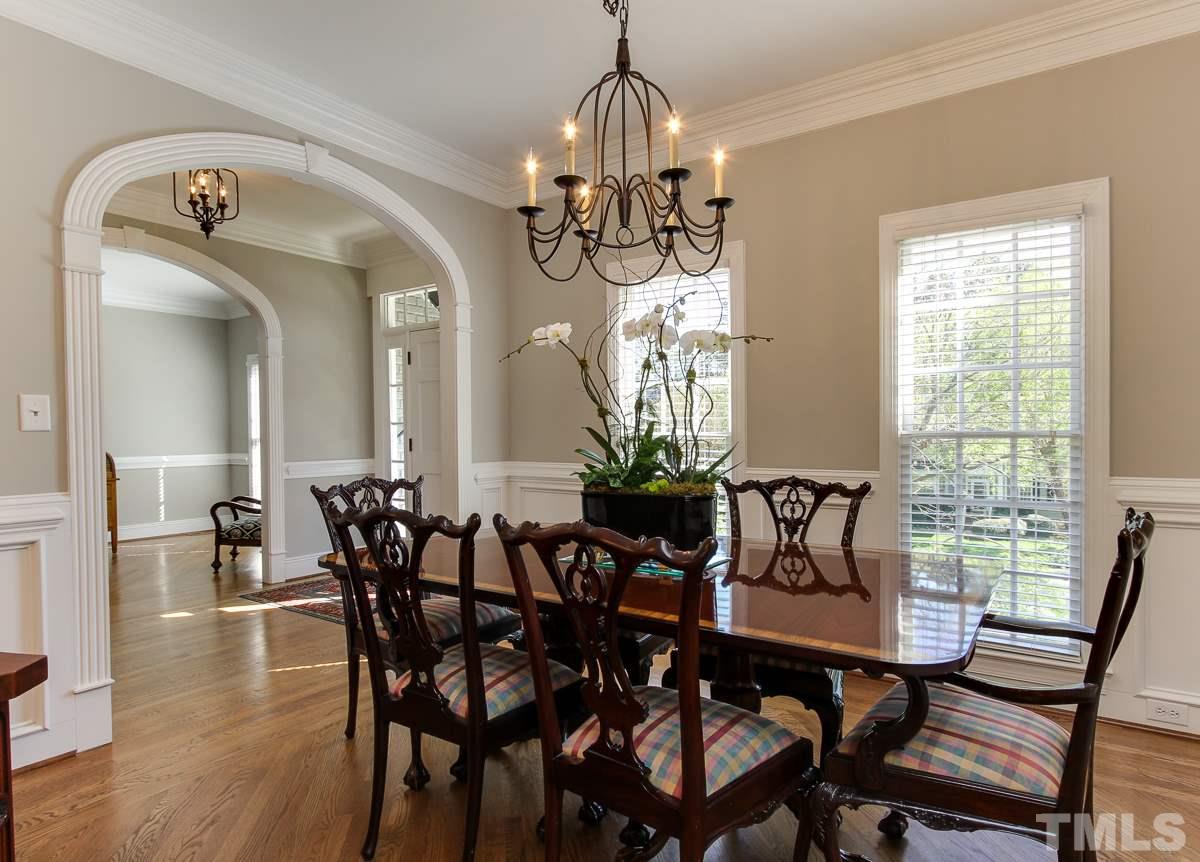 7260 Manor Oaks Drive Raleigh, NC 27615 - Photo 3 of 25 Dining room boasts hardwood floors, wainscoting, chandelier, and plenty of room for hutch and large table.