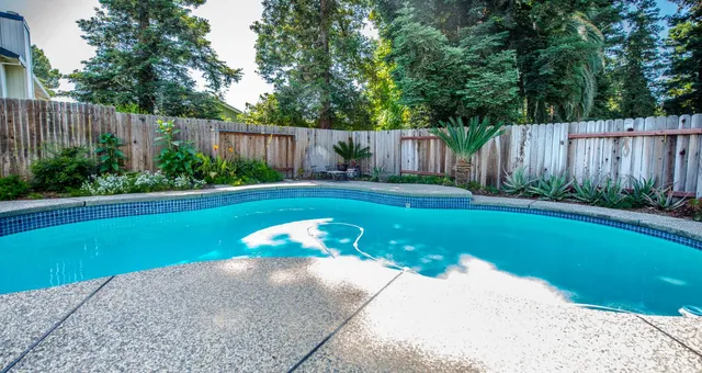 a view of backyard with swimming pool