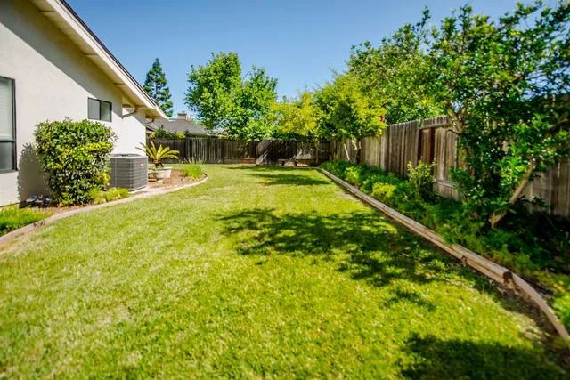 a view of a house with a yard and potted plants