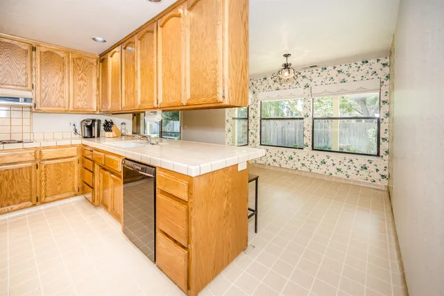 a kitchen with stainless steel appliances a stove a sink and white cabinets with wooden floor