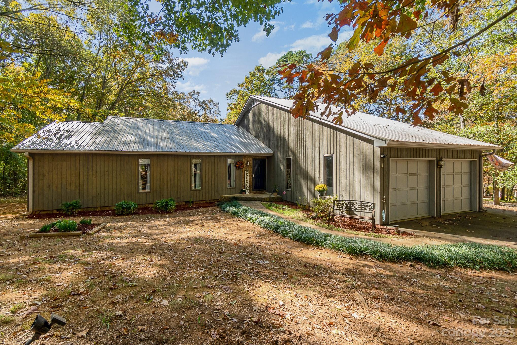 a view of a house with a yard and large tree