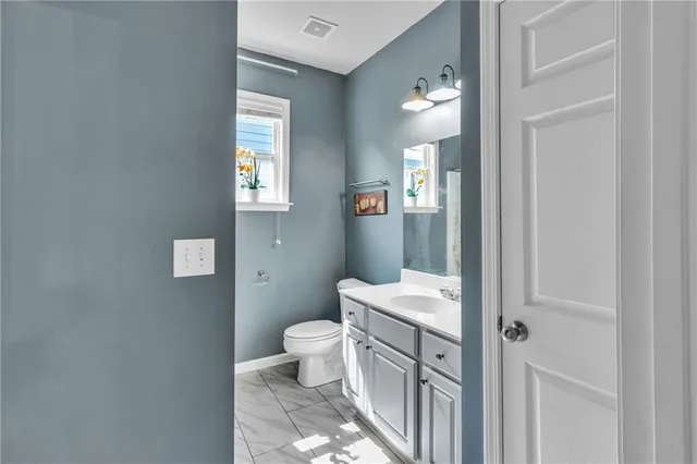 a bathroom with a toilet sink and mirror