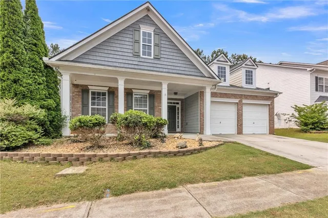 a front view of a house with a garden and plants