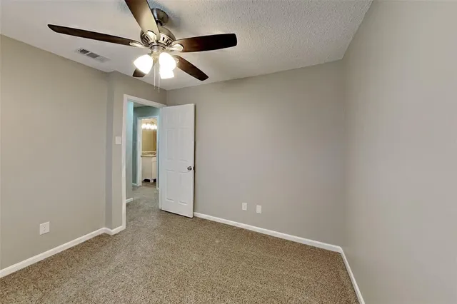 an empty room with closet and a chandelier fan