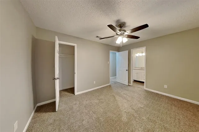 an empty room with closet and a ceiling fan