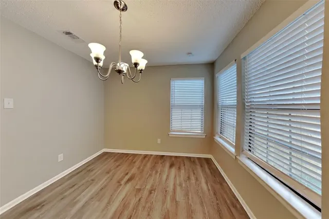 a view of a room with wooden floor and chandelier
