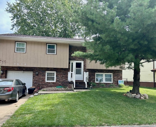 3656 North Meadowlark Drive Decatur, IL 62526 - Photo 2 of 31 a view of a yard in front of a house with plants and large tree