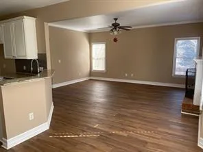 a view of a room with wooden floor and a flat screen tv