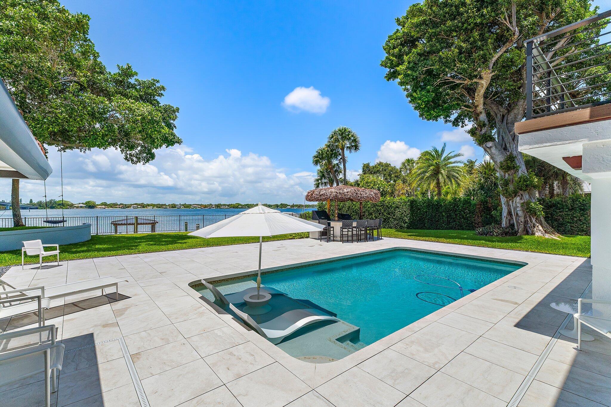 9 North River Road Stuart, FL 34996 - Photo 22 of 24 a view of a swimming pool with an outdoor seating and yard