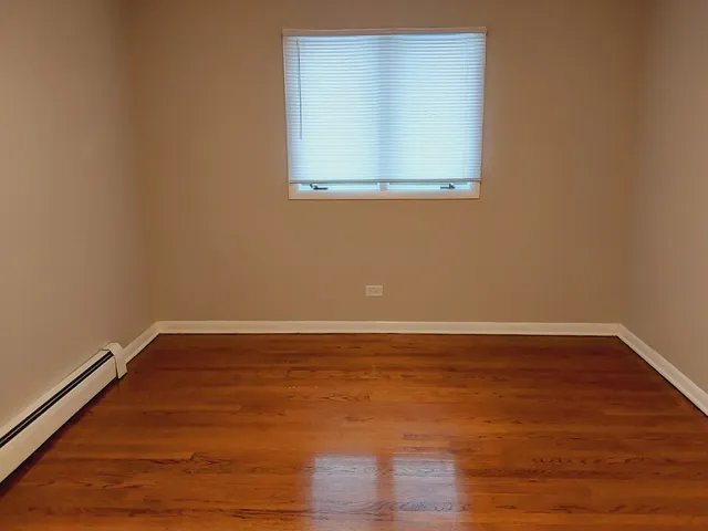 a view of a small space with wooden floor and a window