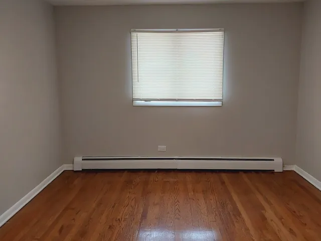 a view of a small space with wooden floor and a window