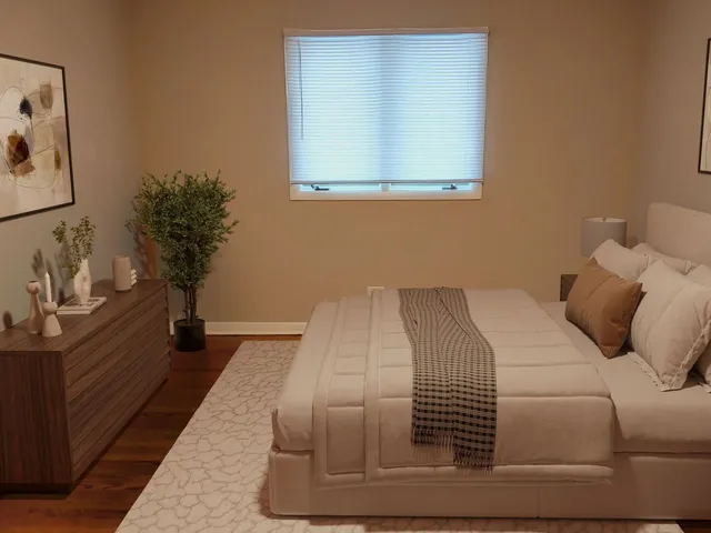 a bedroom with a bed and a potted plant