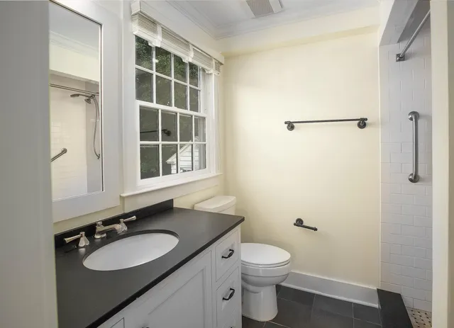 a bathroom with a granite countertop sink toilet and a mirror