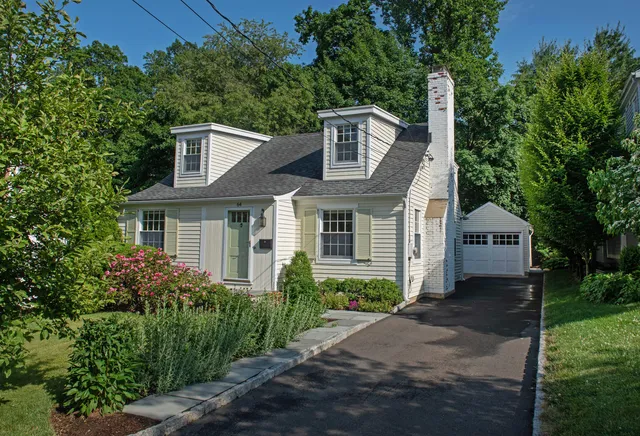 a front view of a house with a garden and plants