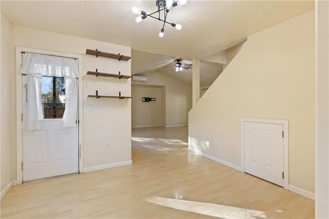 a view of an empty room with a window and kitchen view