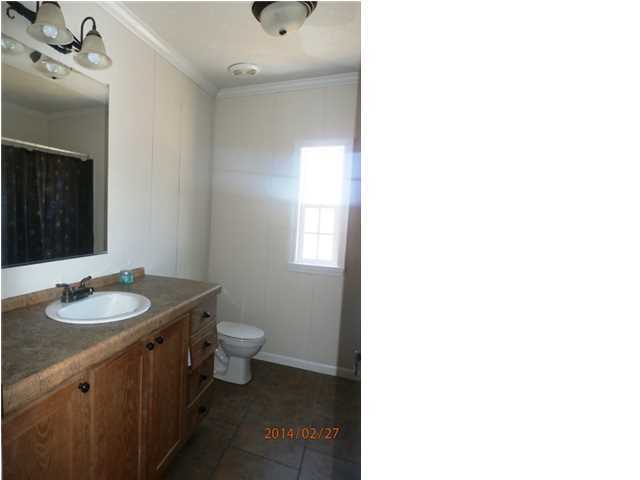 725 Sandy Ramp Road DeFuniak Springs, FL 32433 - Photo 16 of 20 a bathroom with a granite countertop sink a toilet and a mirror
