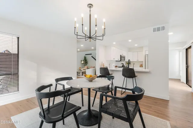 a dining room with furniture a chandelier and wooden floor