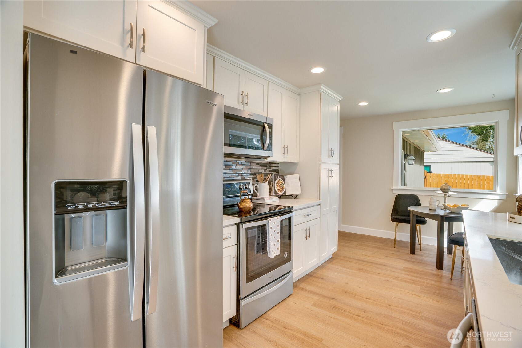 20018 Meridian Place North Shoreline, WA 98133 - Photo 12 of 37 a kitchen with stainless steel appliances a refrigerator a stove a sink a dining table and chairs