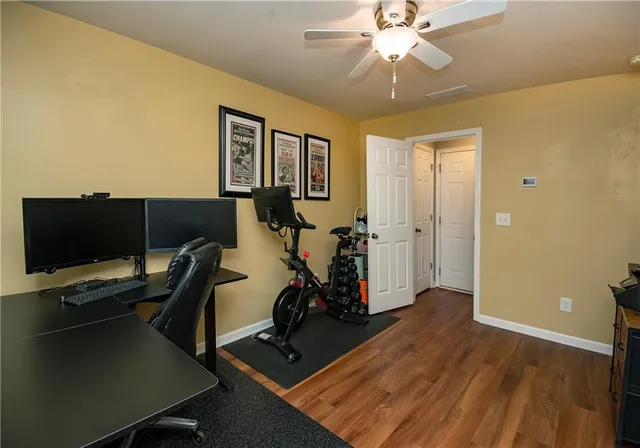 a view of a workspace with wooden floor and gym equipment
