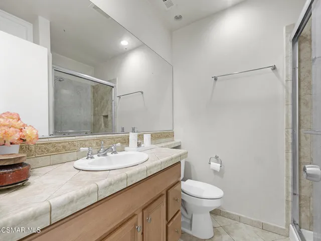 a bathroom with a granite countertop sink toilet and a mirror