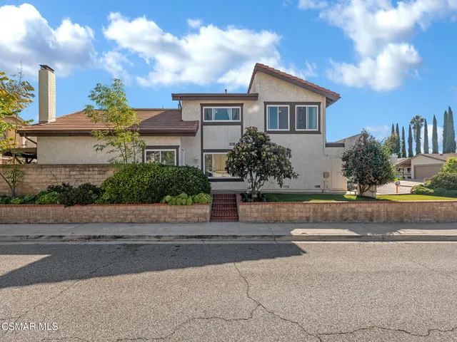 a front view of a house with a yard and plants