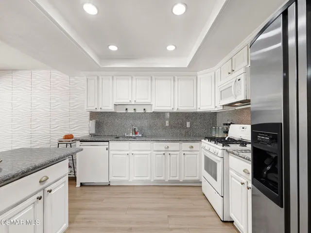 a kitchen with stainless steel appliances granite countertop a stove sink and cabinets