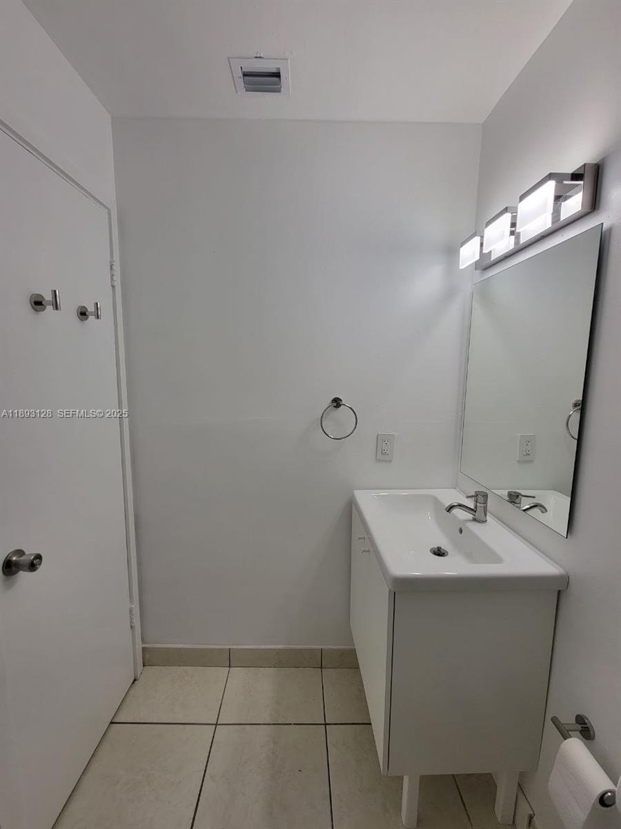 3300 Southwest 9th Terrace Miami, FL 33135 - Photo 20 of 25 a bathroom with a sink a mirror and shower