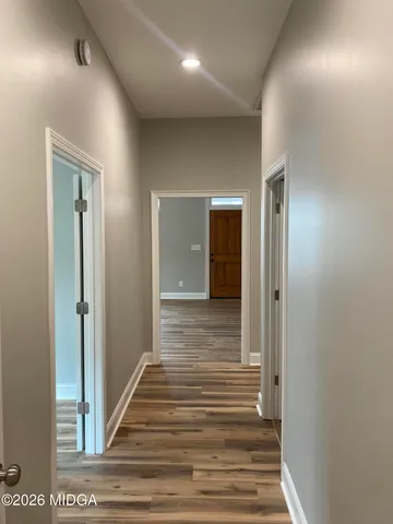 a view of a hallway with wooden floor and closet