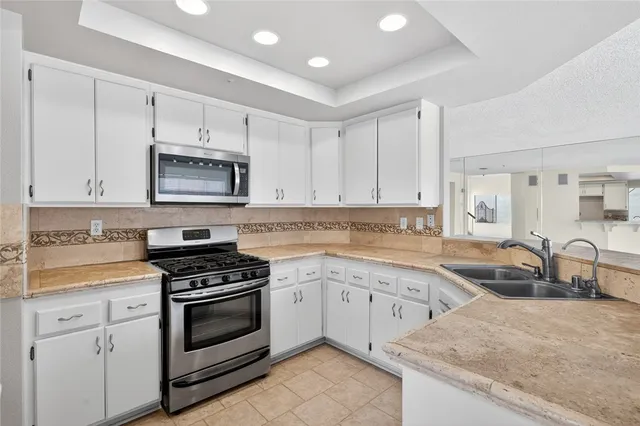 a kitchen with granite countertop a sink stove and cabinets
