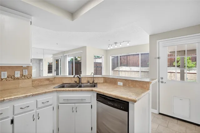 a kitchen with granite countertop a sink and white cabinets