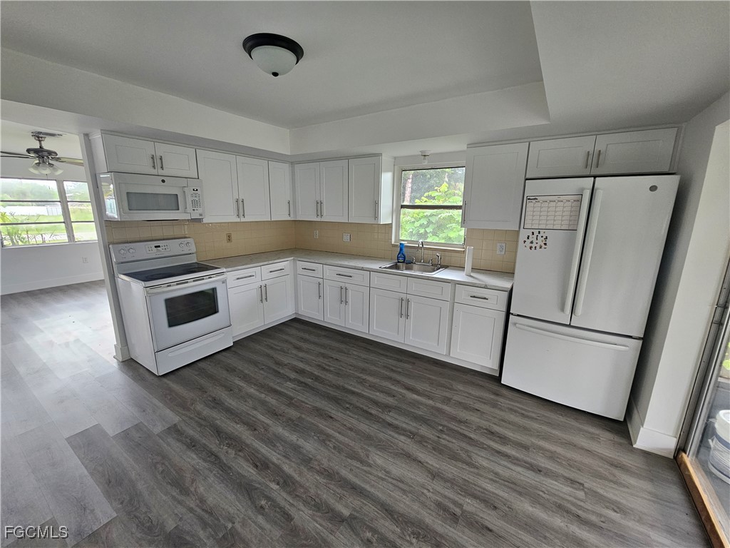 5487 Judith Road Bokeelia, FL 33922 - Photo 4 of 18 a kitchen with white cabinets and white appliances