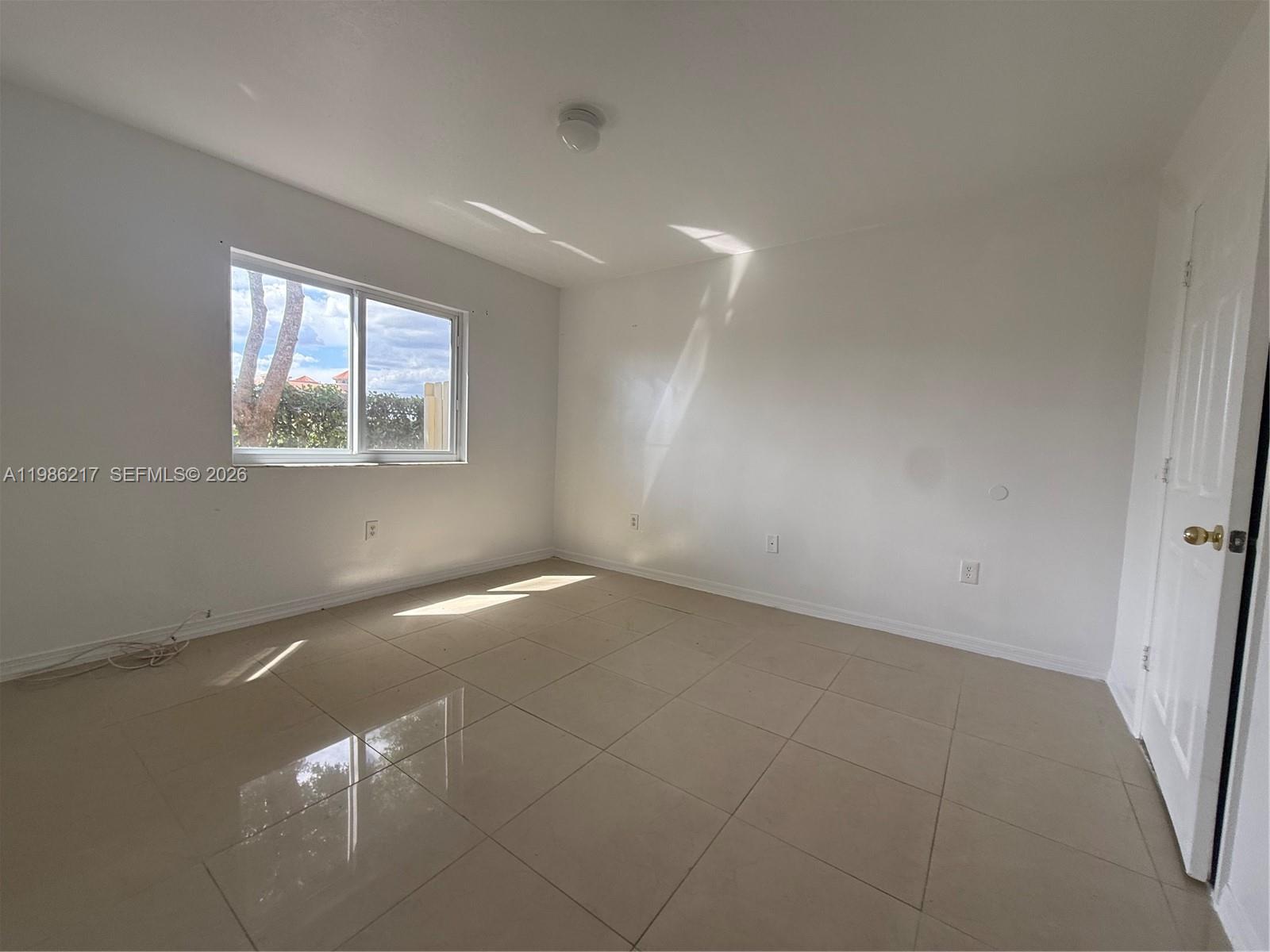 940 Northeast 33rd Terrace, Unit 101 Homestead, FL 33033 - Photo 11 of 20 an empty room with windows