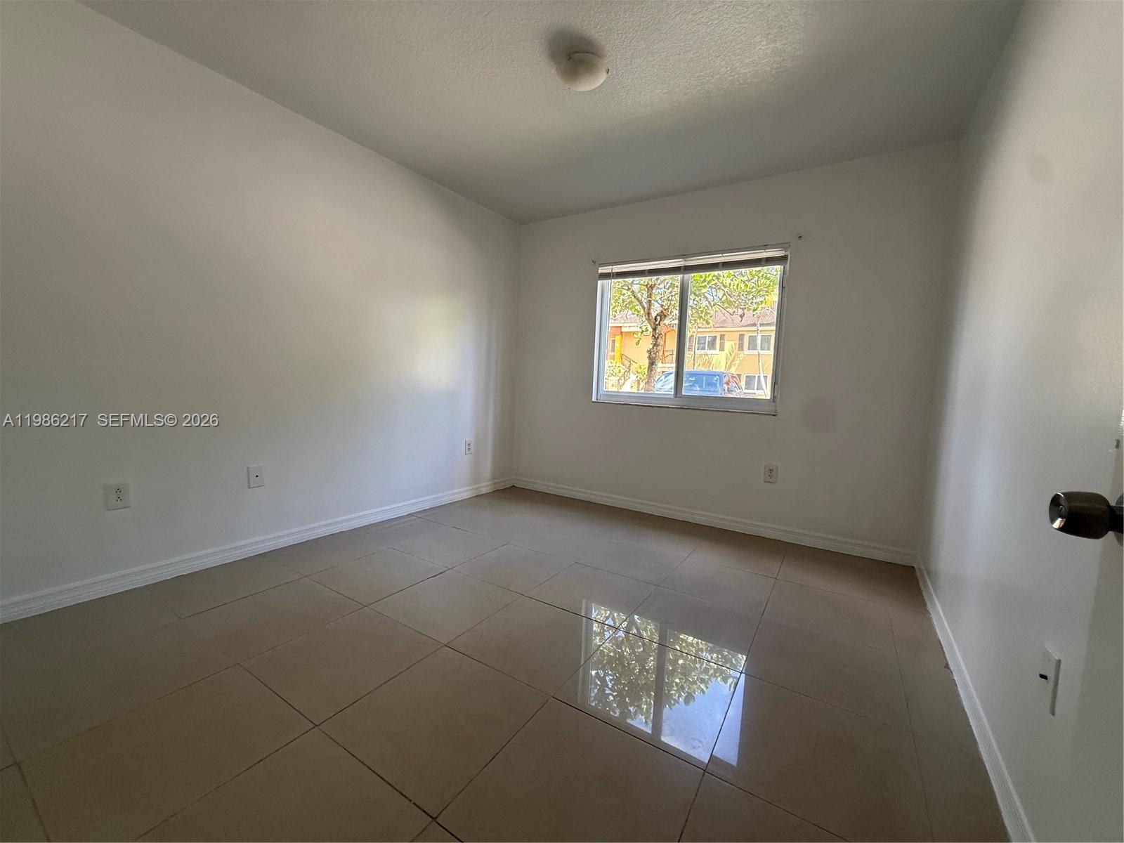 940 Northeast 33rd Terrace, Unit 101 Homestead, FL 33033 - Photo 14 of 20 an empty room with a window
